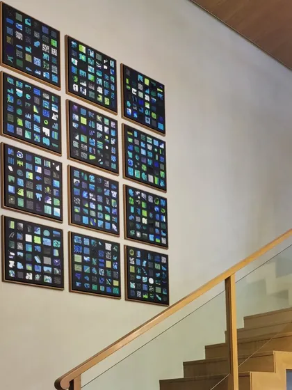 A multi-panel installation of twelve individual canvases, each featuring abstract textural paintings in shades of blue and green. This collection creates a stunning gallery wall on a staircase.