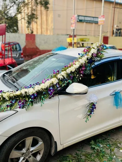 For a unique and royal look, I use premium flowers like these blue orchids. This design on a white Hyundai Elantra features a beautiful arrangement of white flowers and blue orchids.