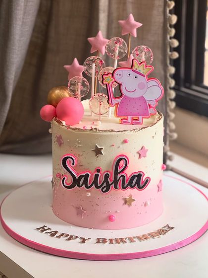 A Peppa Pig pink fantasy come true! This cake is perfect for a little one's birthday, adorned with a Peppa topper, magical stars, and glittery isomalt lollipops for a touch of sparkle.