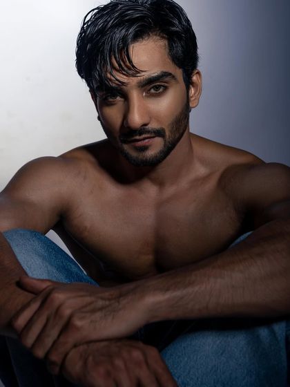 A powerful, shirtless portrait that focuses on physique and intensity. I used dramatic, shadowy lighting to sculpt the model's muscles and create a moody, confident image. This is great for fitness portfolios or edgy fashion looks.