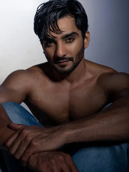 A powerful, shirtless portrait that focuses on physique and intensity. I used dramatic, shadowy lighting to sculpt the model's muscles and create a moody, confident image. This is great for fitness portfolios or edgy fashion looks.