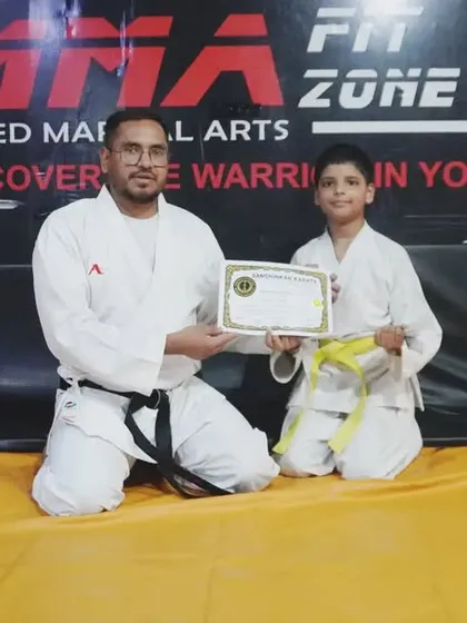 Another young student proudly displays his new yellow belt. Our kids' program is focused on building skills and celebrating every achievement.