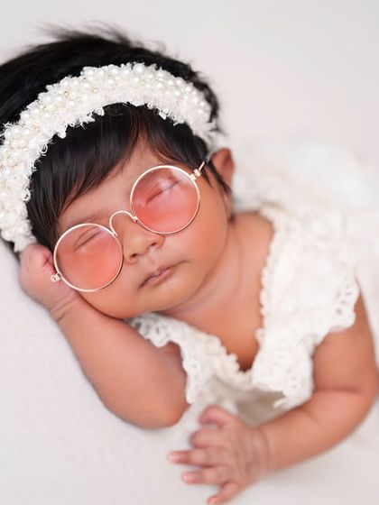 Adding a touch of cool with pink sunglasses to this otherwise simple and classic white lace outfit.