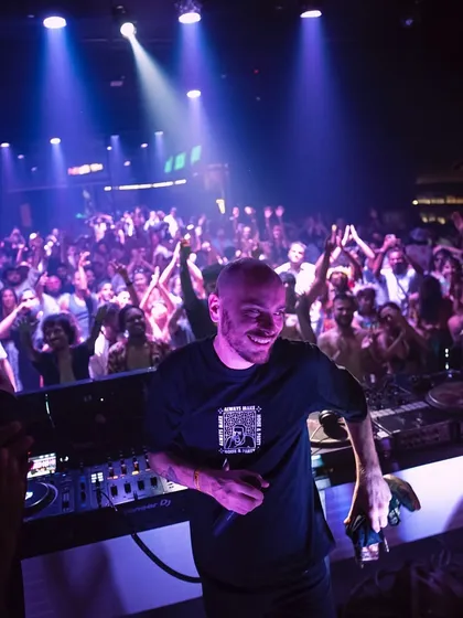 A DJ smiles as he looks out at the massive crowd at Goa Sunsplash. It's a rewarding moment to see the dancefloor completely packed and loving the selections.