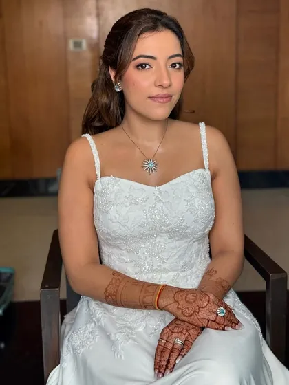 A seated portrait of my Christian bride. Her makeup is soft and romantic, with gentle contouring and a natural lip, perfect for her elegant white dress.