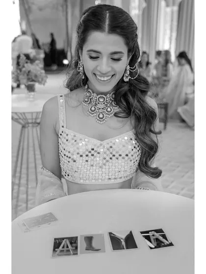 Alya reacts with joy to a magic trick. This candid portrait captures her genuine delight and the fun, interactive elements of their celebration.