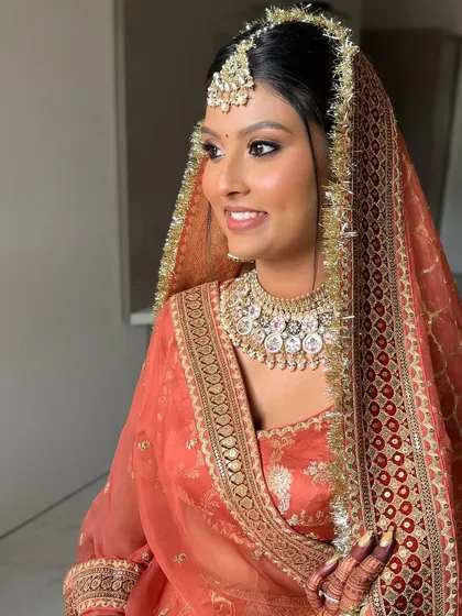 A side profile showing the warm, sculpted makeup on her beautiful brown skin. The goal was to enhance her glow, not mask it.