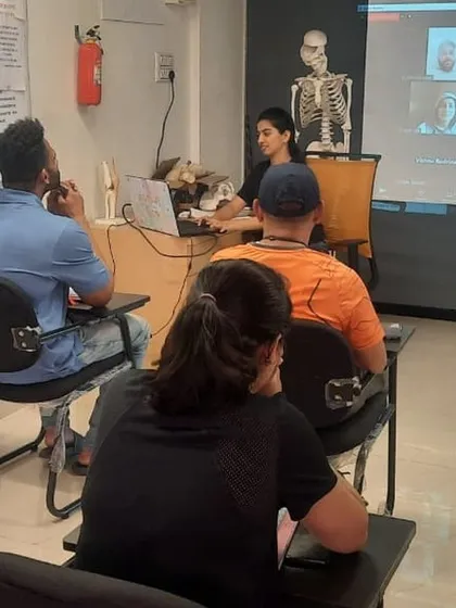 Our hybrid classroom setup, with a skeleton for anatomical reference, a projector for online students, and in-person attendees. We make quality education accessible to everyone.
