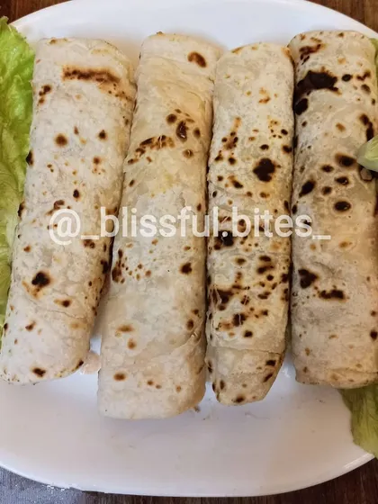 My Smokey Chicken Rolls, filled with flavourful chicken and wrapped in a soft, flaky flatbread. They are served here with a side of fresh salad.