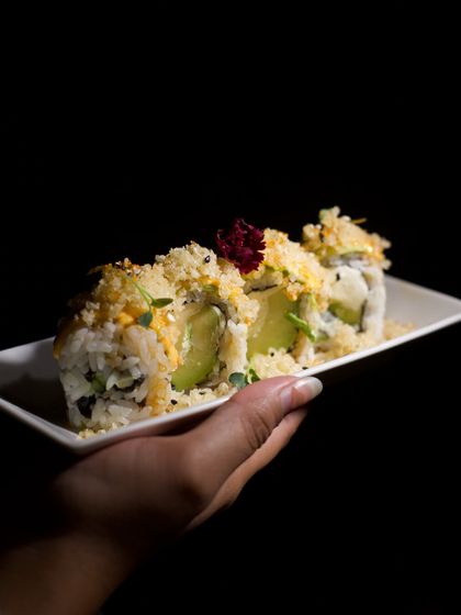 A close-up of our crunchy avocado sushi rolls, garnished with an edible flower. This demonstrates our attention to detail and texture in our global cuisine offerings.