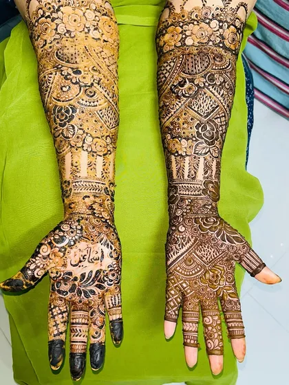 A stunning bridal design with full coverage. The groom's name, "Ismail," is beautifully written on the palm.