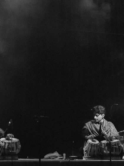 The talented tabla players who joined me on stage, caught in a moment of rhythmic exchange under the stage lights.