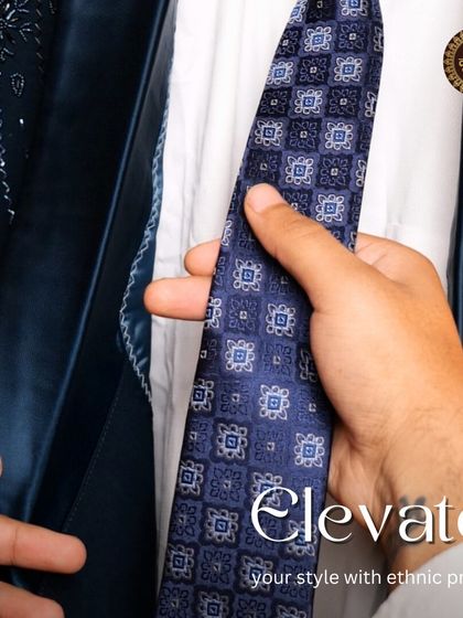 Elevate your style with ethnic pride. A close-up on the navy tuxedo, showing the detail of the tie and the satin lapel.