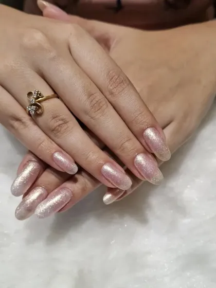 Light up your Diwali with these stunning glitter nails. This set features a beautiful rose gold shimmer on long oval nails, creating a look that's festive, glamorous, and full of sparkle.