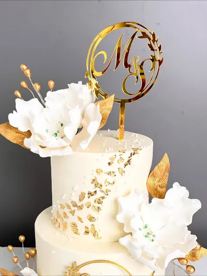 A close-up of the custom "M & S" monogram topper on the elegant engagement cake.