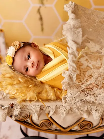 This little one is wide-eyed and curious in her vintage-style pram during a sunflower-themed newborn session. We always follow the baby's lead, capturing both sleepy and awake moments.