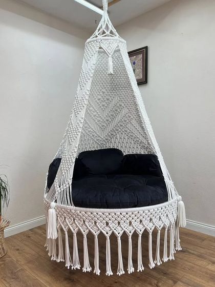 A classic white swing with a black cushion. This timeless black and white combination is perfect for a minimalist or modern decor style.