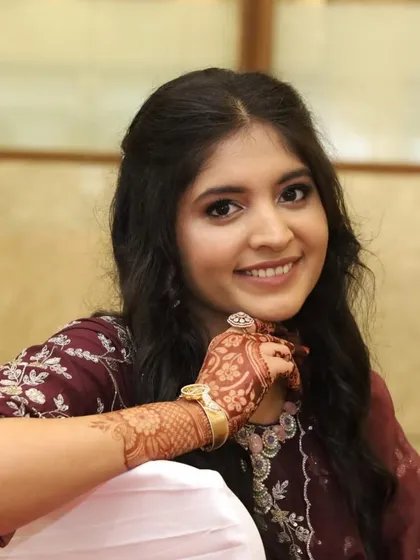 A close-up portrait of the engagement bride. Her soft makeup look is complemented by her intricate mehendi and beautiful jewelry.