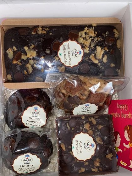 An example of a custom Rakhi hamper, this box includes a healthy whole wheat jaggery tea cake, a classic walnut fudge brownie, two Bounty New York cookies, and one Nutella-filled New York cookie.