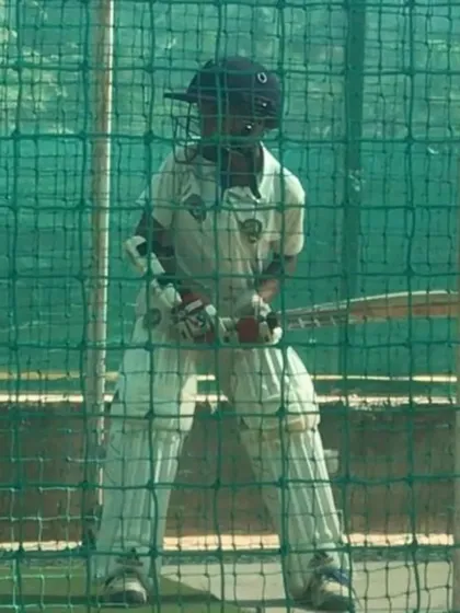 A young player padded up and focused during a net session, ready to face the next ball.