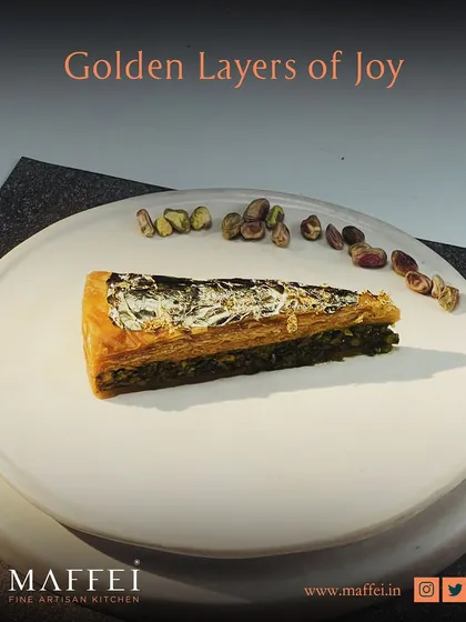 Golden layers of joy. Our classic baklava features crisp phyllo pastry, a rich nut filling, and a silver leaf garnish, offering a bite of pure, sweet tradition.