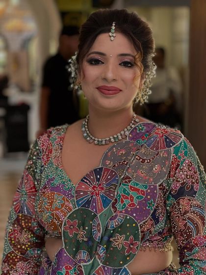 A smiling portrait of the client, showing how the makeup enhances her features and complements her unique outfit.