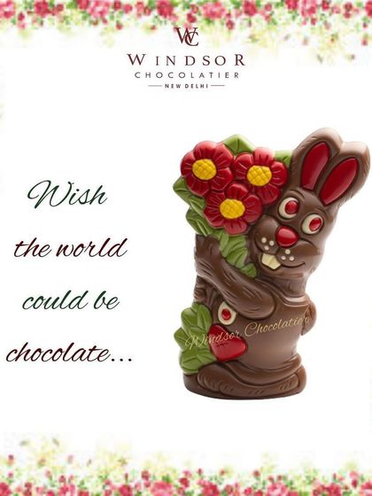 This chocolate bunny is holding a large bouquet of flowers, showcasing detailed molding and colorful accents.
