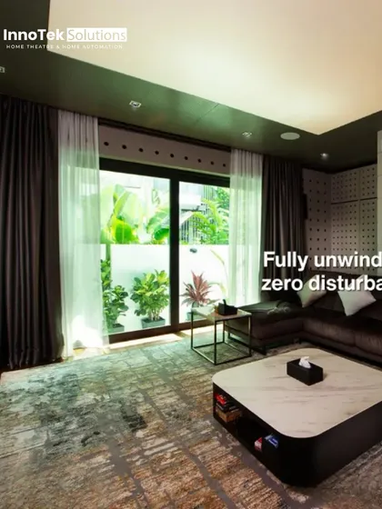 The same space can be a bright, airy living room by day. This image shows how our installations work with your home's natural light and decor, with heavy curtains ready to create a dark theater environment when needed.
