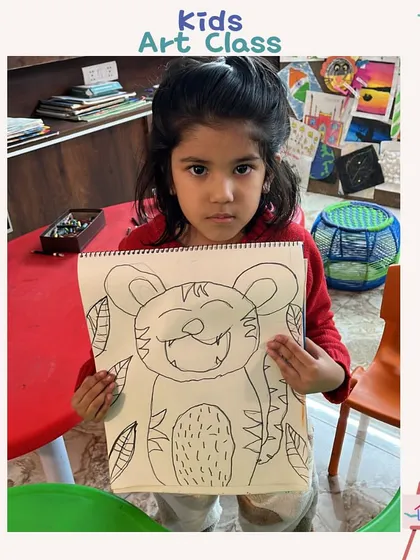 A student proudly holds up her tiger drawing. In our art classes, every child becomes an artist in their own way, exploring colors and imagination.