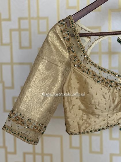 The sleeve of the gold blouse, with a sheer panel on the cuff.