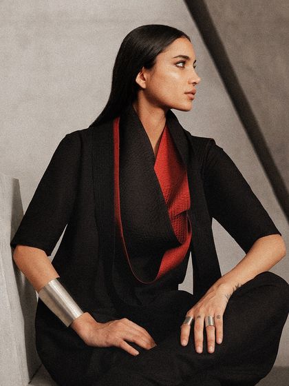 A closer view of the previous look, highlighting the texture of the fabric and the bold silver cuff, which adds to the sculptural feel of the styling.