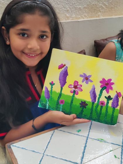 Another proud young painter showing off her bright and cheerful floral artwork on canvas.