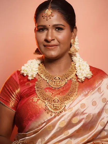 A full view of the TBO signature South Indian bridal look. The makeup perfectly complements the rich silk saree and temple jewelry.