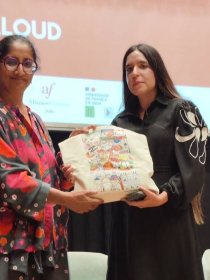 A winner of the Read Aloud competition receives a prize bag on stage. We celebrate the passion and dedication of our students in mastering the French language.