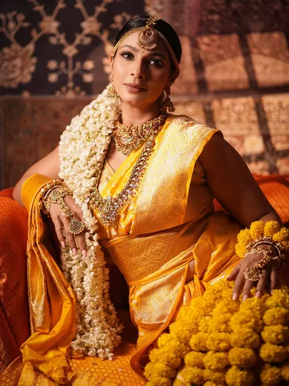 Embodying divine energy with Tanishaa Mukerji. This look is all about traditional grandeur, featuring a rich yellow Kanjeevaram saree, heavy temple jewelry, and a long gajra of fresh jasmine flowers for an authentic South Indian bridal feel.