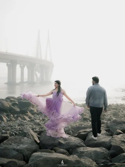 The flowing purple dress creates a stunning visual against the muted tones of the misty morning. This is a great example of a dramatic coastal portrait.