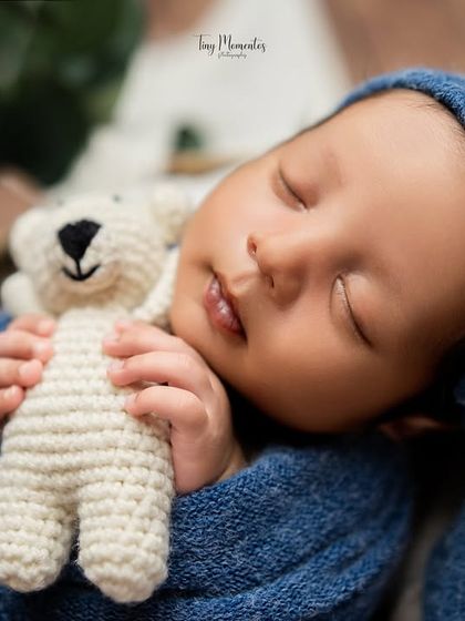 Dreaming the sweetest dreams with a tiny friend. This close-up shot in deep blue tones captures the pure innocence of a sleeping newborn.