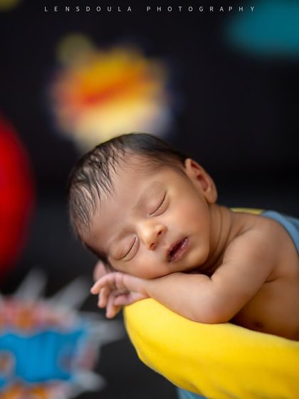 A close-up of our little superhero, sleeping soundly, unaware of the epic city skyline and action bubbles that make up his adventurous backdrop.