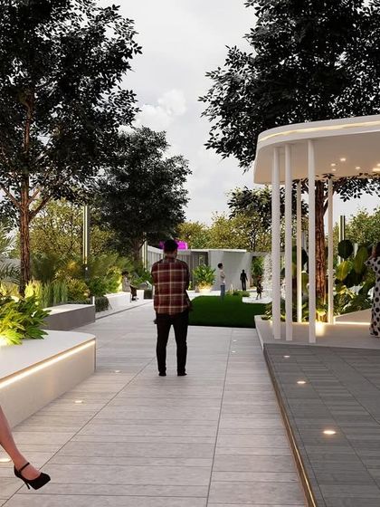 This community space features tiered, amphitheater-style seating with integrated lighting, perfect for social gatherings. A modern white pergola provides a sheltered spot, while the surrounding trees and pathways encourage movement and interaction.