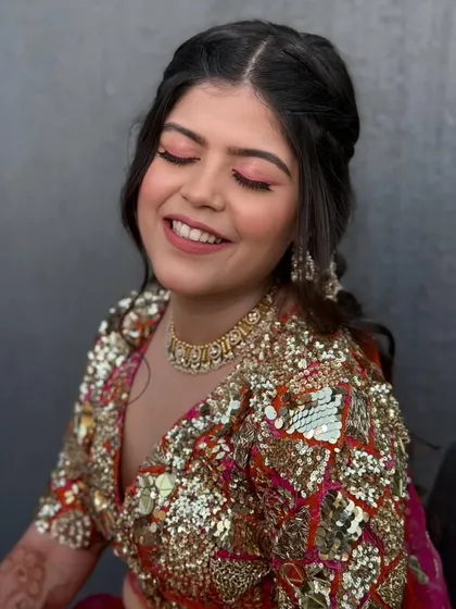 The bride smiling with her eyes closed, showing off the vibrant pink eyeshadow. It's a playful and bold look for a fun-loving bride.