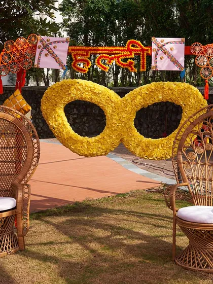 A quirky and fun photobooth idea for a Haldi function. I created this giant pair of sunglasses from flowers, providing a unique spot for guests to take pictures.