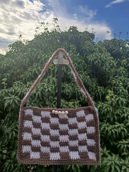 Another checkered bag, this time in a warm brown and white with a pearl button closure. This shows a different take on the same popular pattern.