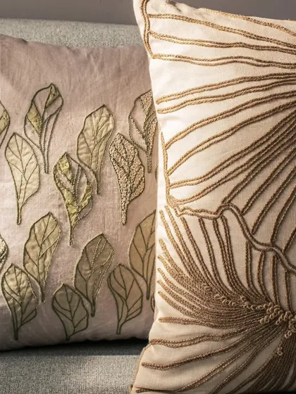 The fine craftsmanship of our hand-embroidered cushions is evident in this detailed shot. The leaf motifs are created with varying stitching techniques to give them depth and a lifelike quality.