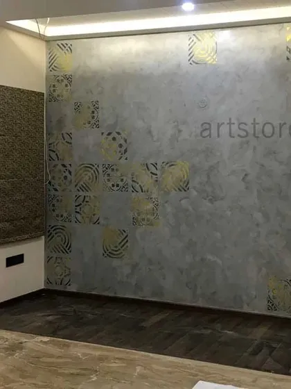We created this elegant bedroom accent wall using a soft, cloudy grey base texture. The look is elevated with geometric and floral patterns stenciled in a shimmering metallic gold paint, adding a touch of luxury and warmth.