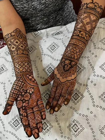 A simple yet elegant engagement mehendi. The design features a mix of floral and geometric patterns, covering the hands and forearms.