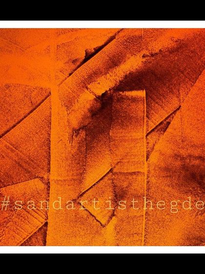 An abstract sand painting with bold, intersecting shapes. The intense orange color and rough texture give this piece a powerful, energetic feel.