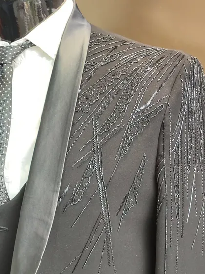 A close up of the intricate, abstract beadwork and embroidery on the shoulder of our custom grey designer suit.