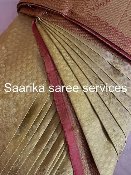 A beige brocade saree with a pink border, folded with care.