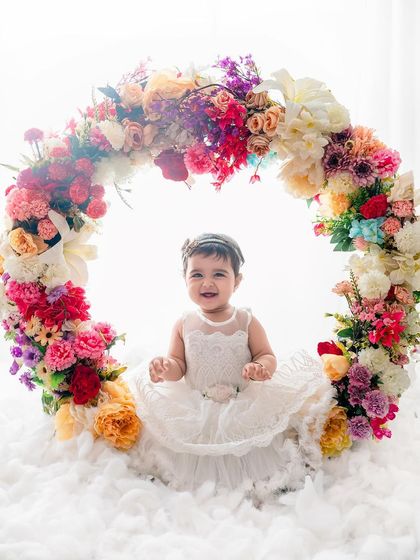 A beautiful smile from the birthday girl, sitting in a magical floral ring. This is a perfect portrait to mark a special milestone.