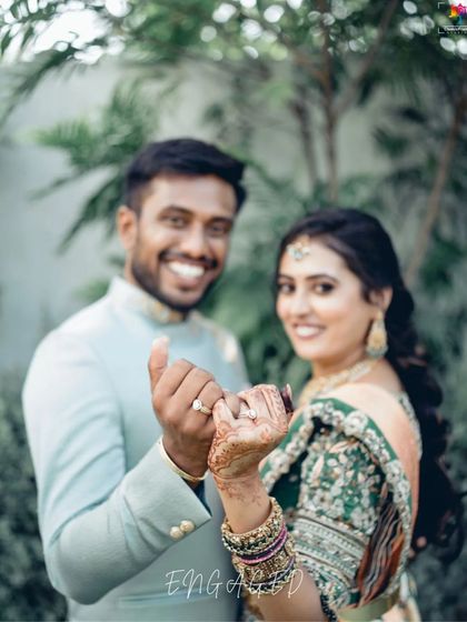 A joyful, candid shot of the couple showing off their engagement rings. Their genuine smiles and playful pose make this a heartwarming memory.